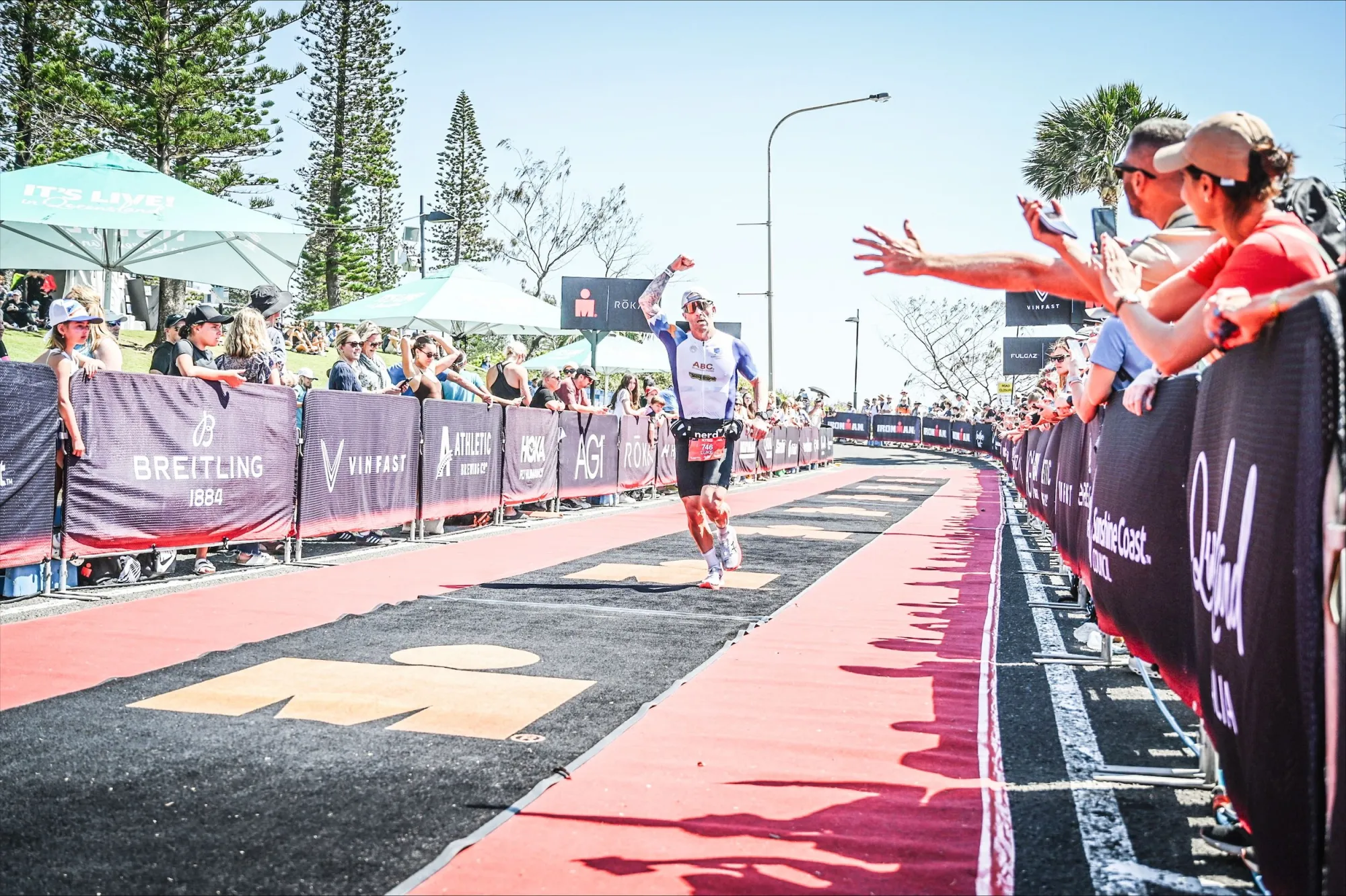 A triathlete celebrating at an IRONMAN finish line