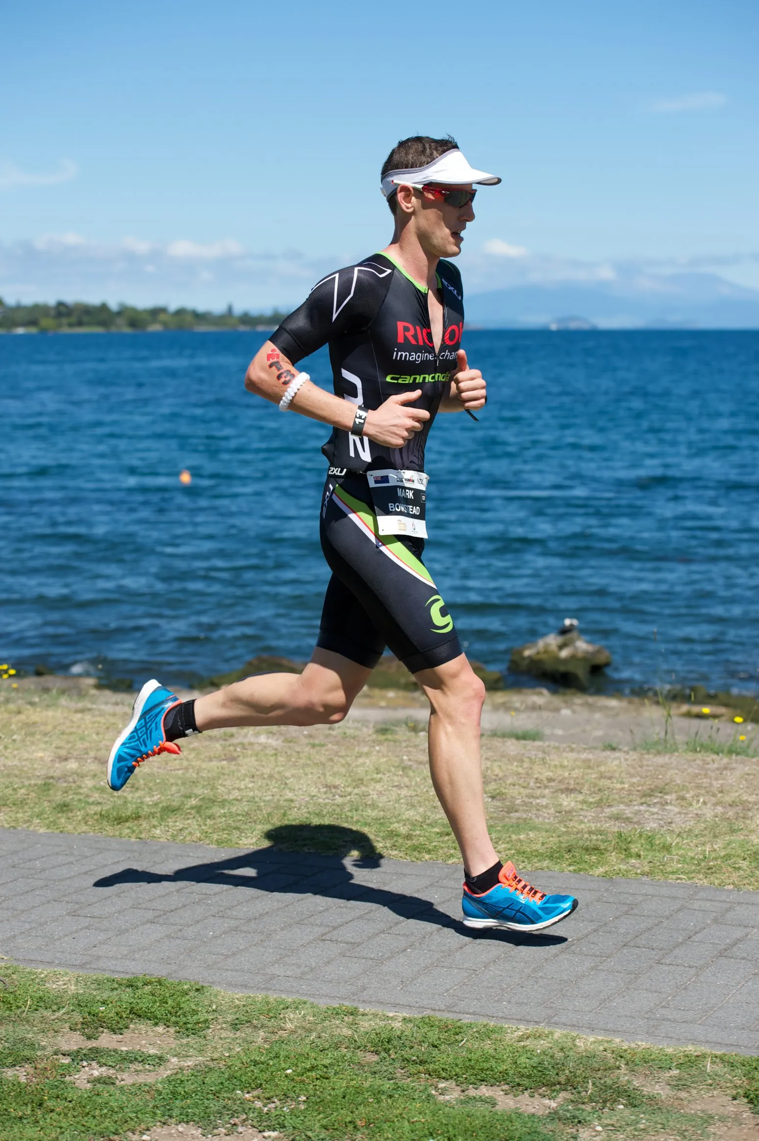 Mark Bowstead running beside Lake Taupo on the IRONMAN New Zealand marathon course