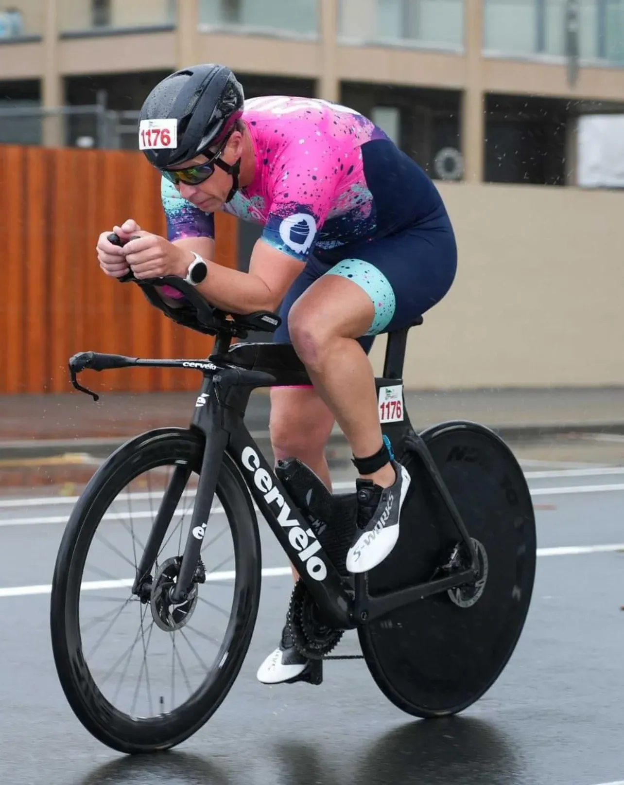 An athlete in a pink race suit on a time trial bike