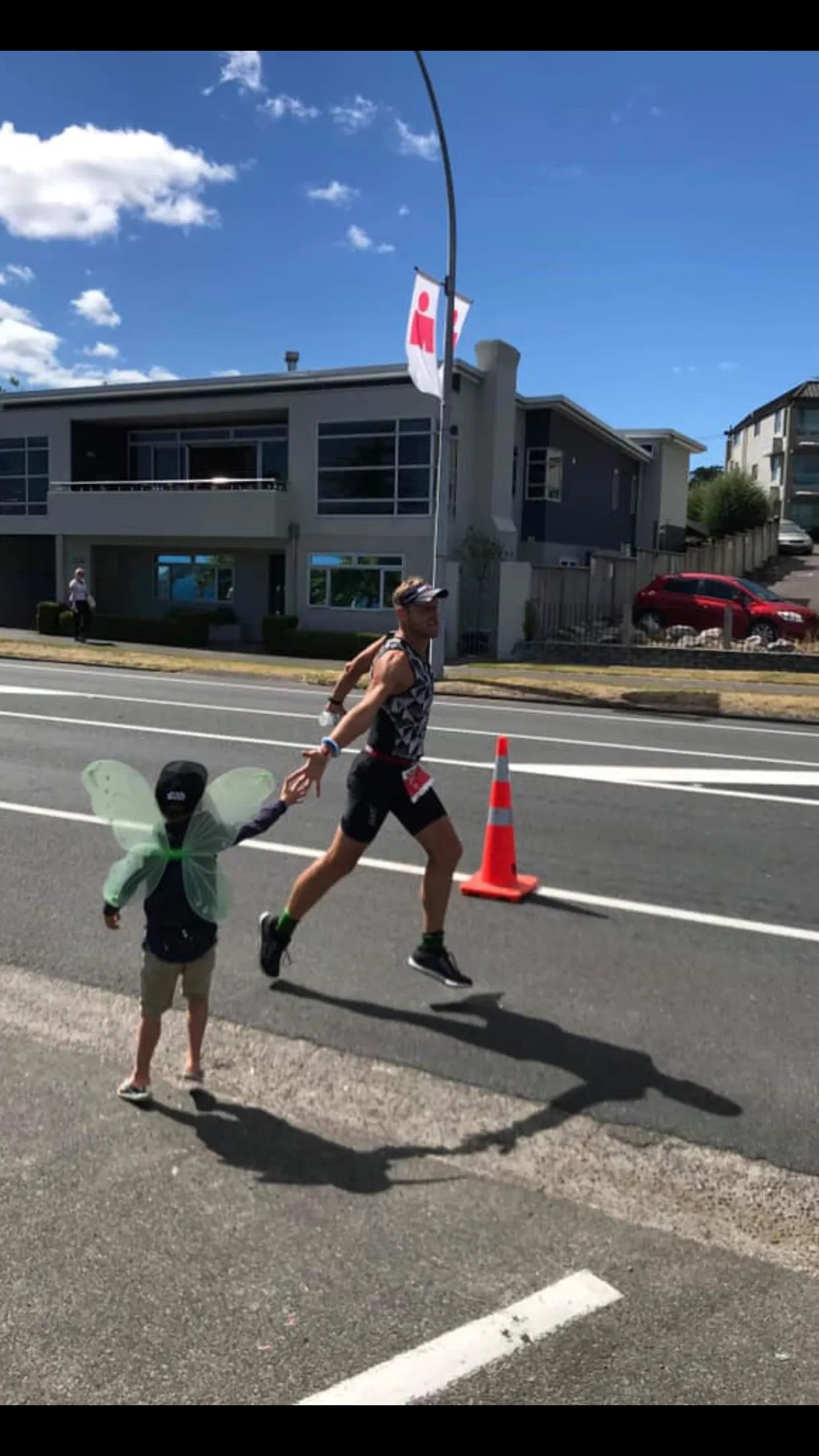 Tim Anderson high-fiving a young supporter in fairy wings on the run course